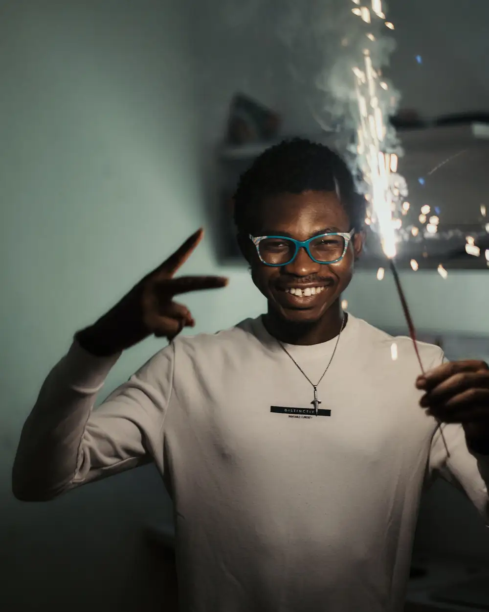 Black African man holding a sparkler to celebrate the new year.