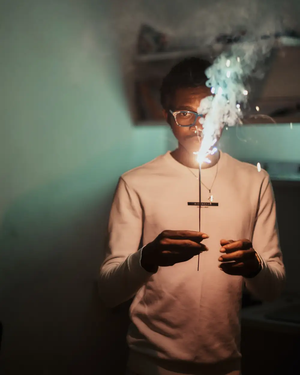 Black African man holding a sparkler to celebrate the new year.