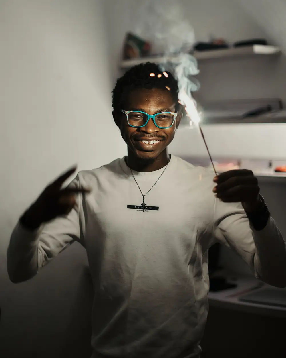 Black African man holding a sparkler to celebrate the new year.