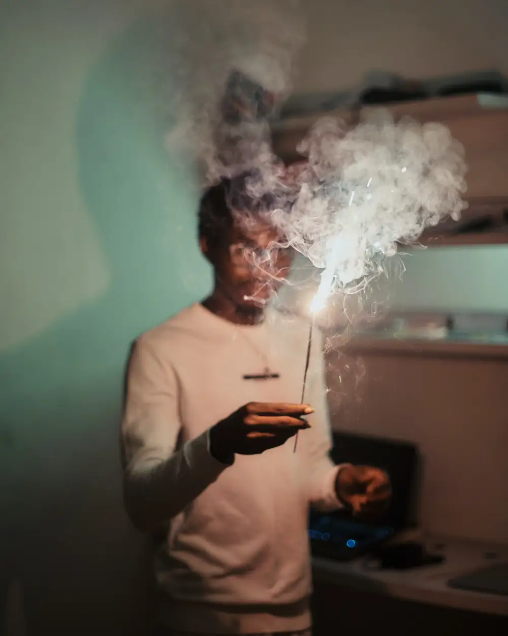 Black African man holding a sparkler to celebrate the new year.