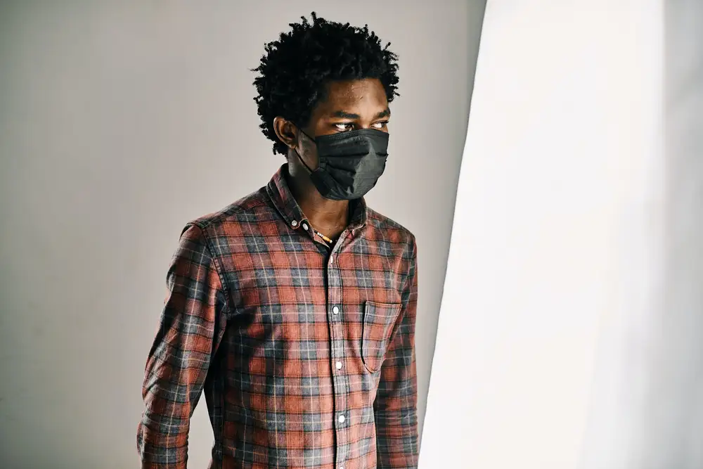 A stylish young black man wearing a black mask to prevent infections like covid19.