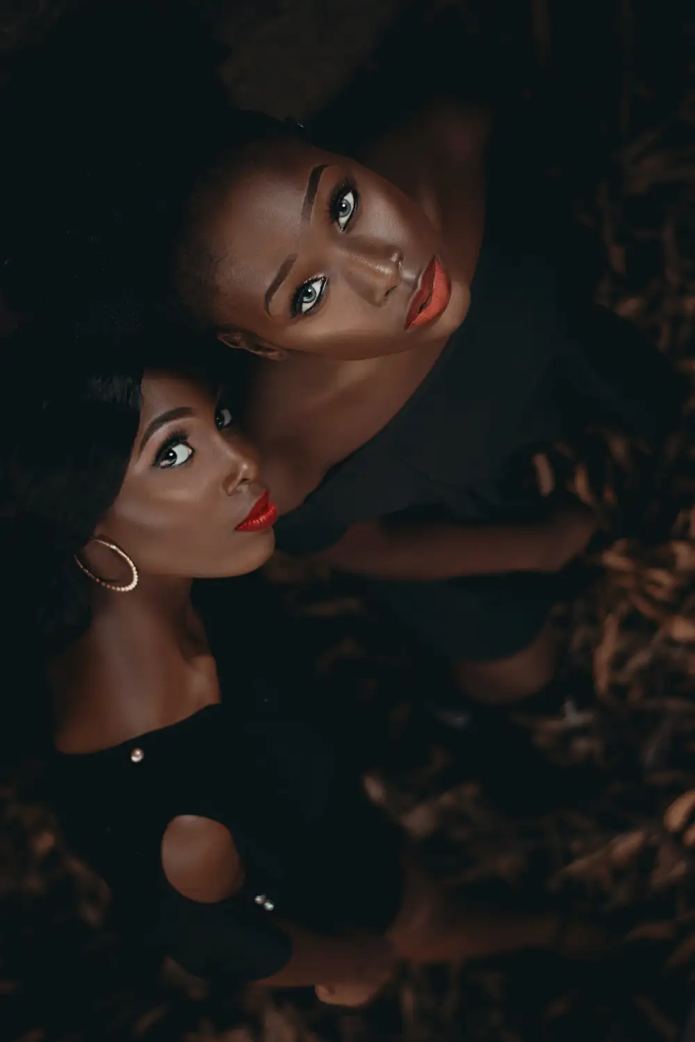 Portrait of black African young women in black gowns with afro hairstyle standing together. African female models looking at the camera.