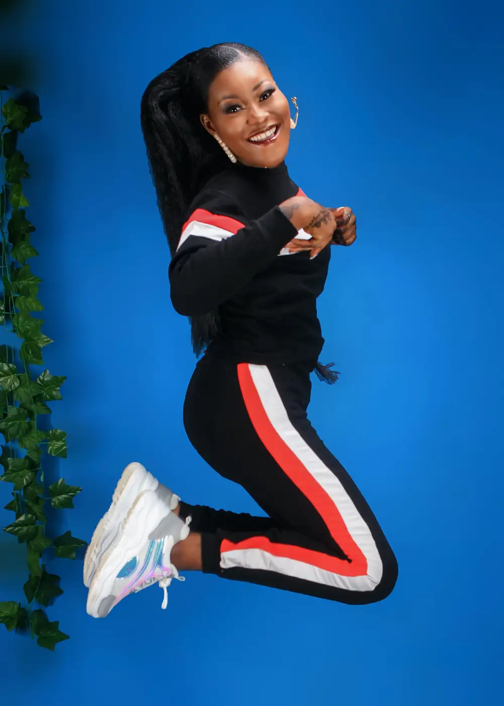 Woman in black and orange track suit jumping