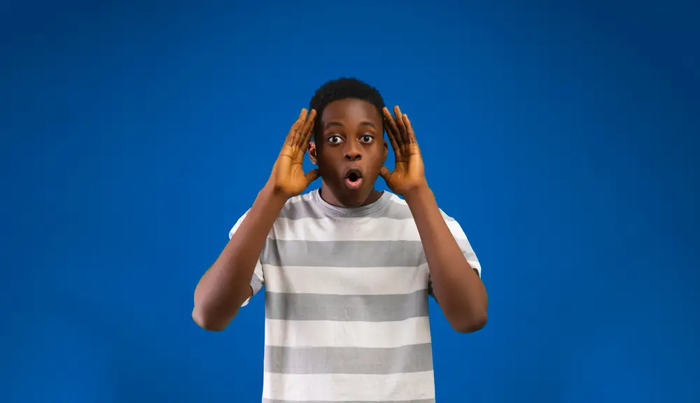 young man holding his head with shocked expression