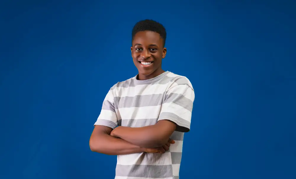 young man folding his arms and smiling