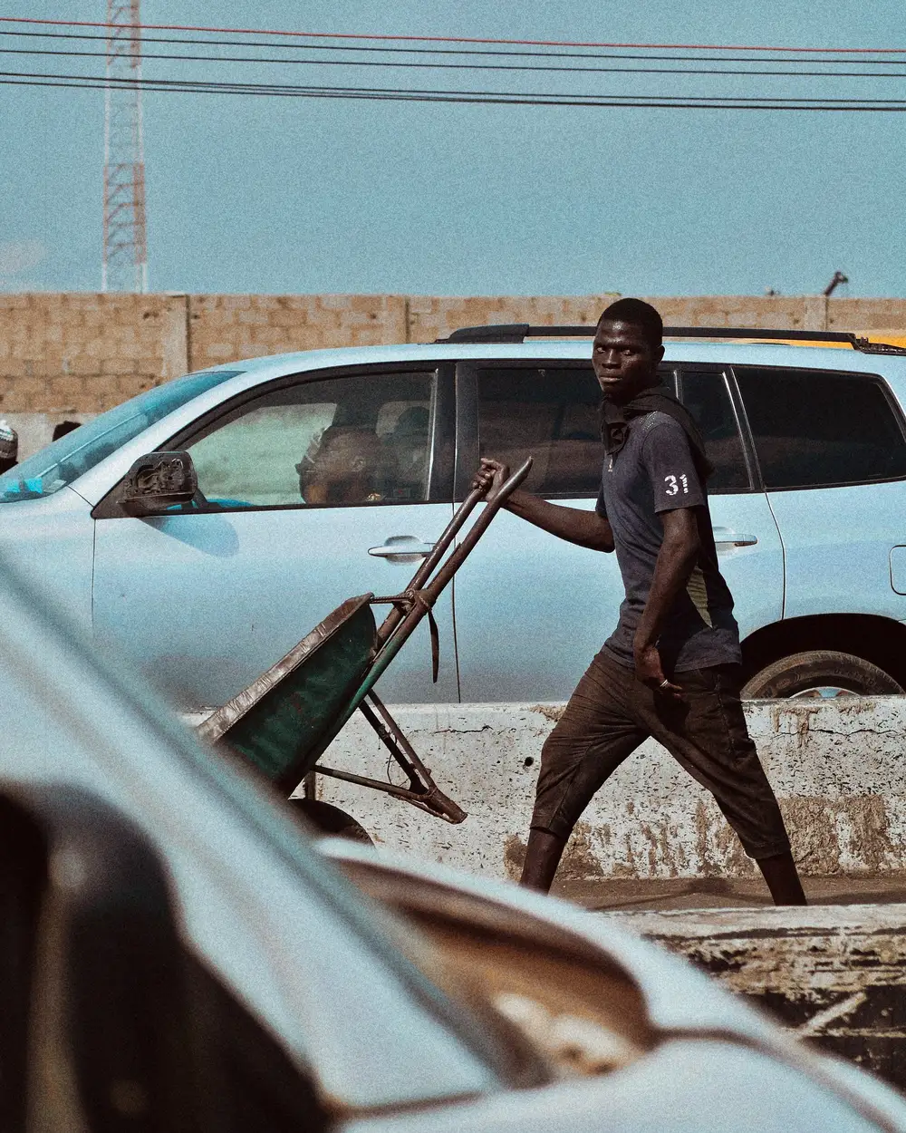 Alabaru (A Porter) rolling a wheel barrow in Lagos Market as a means of survival.