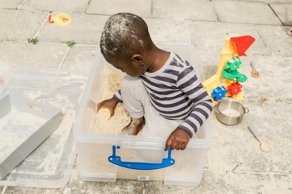 Toddler playing in a sand box