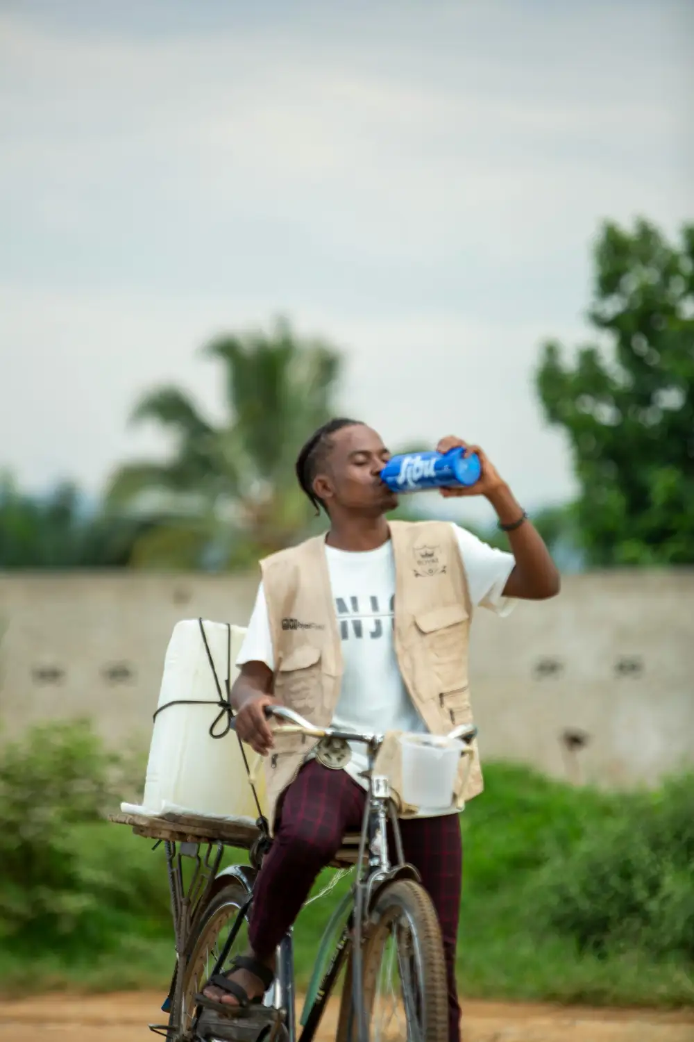 man on bicyle drinking water