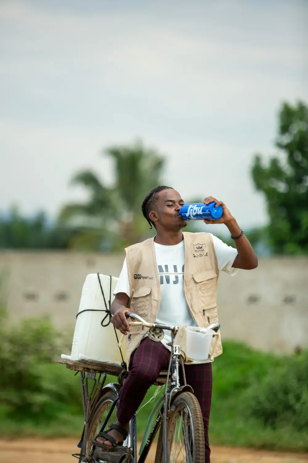 man on bicyle drinking water