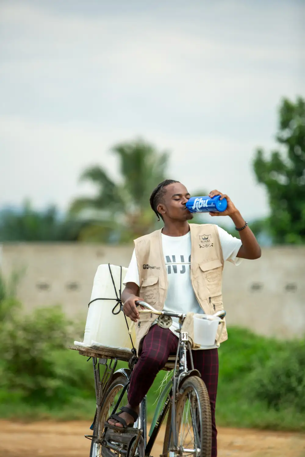 man on bicyle drinking water